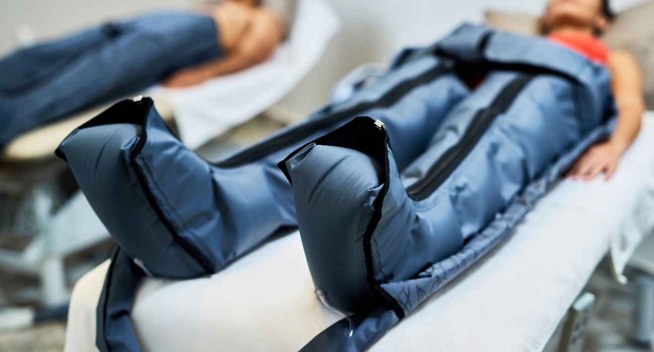 Mujer realizando presoterapia tumbada en la clínica