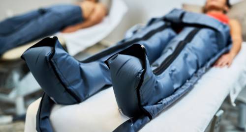 Mujer realizando presoterapia tumbada en la clínica